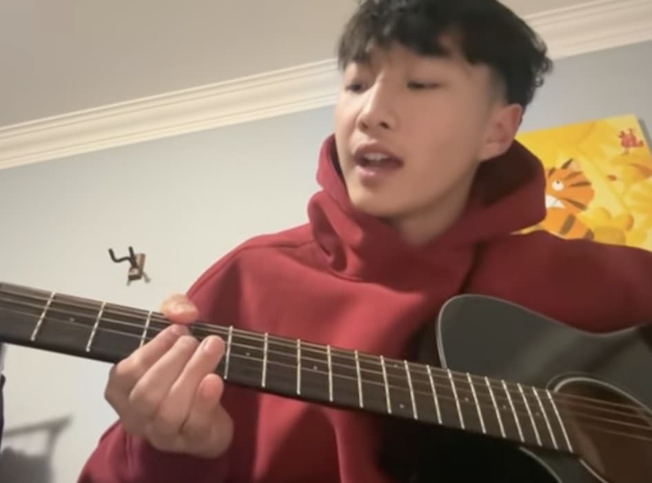 Nick playing guitar and singing at home
